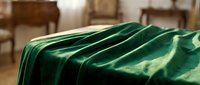 Luxurious emerald green velvet fabric with deep folds and rich texture, perfect for upholstery, fashion design, and interior decoration projects.