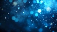 Magical blue bokeh lights and sparkles on dark background create dreamy atmosphere with glowing particles and blurred circles for festive designs.