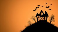 Spooky haunted house silhouette on hill with bats flying against orange sky and boo text. Halloween scene with bare trees creates eerie atmosphere for seasonal designs.