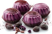 Purple chocolate candies with berry filling and chocolate sprinkles on white background. Gourmet dessert confectionery with dark chocolate pieces.