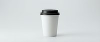White disposable coffee cup with black lid isolated on light background for branding mockup and cafe marketing materials.