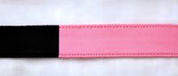 Pink and black elastic band with decorative stitching detail on white fabric background, close-up view showing texture and pattern for fashion and craft design.