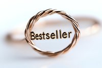 Rose gold twisted ring with bestseller text engraved on metallic surface against soft blurred background, modern jewelry design concept for success.