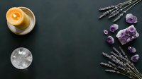 Spa wellness flat lay with burning candle, amethyst crystals, selenite and dried lavender on dark background for relaxation and meditation practices.