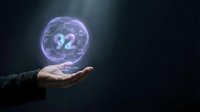 Businessman hand holding glowing holographic sphere with number 92 floating above palm against dark background for futuristic technology concepts.