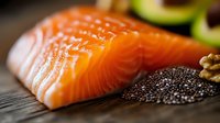 Fresh raw salmon fillet with chia seeds, avocado and walnuts on dark wooden background. Healthy omega-3 rich ingredients for nutritious meal preparation.