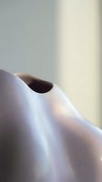 Abstract close-up of smooth curved surfaces with soft lighting creating gentle shadows and highlights in neutral tones for modern design projects.