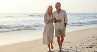 Happy mature couple walking together on sandy beach at sunset enjoying romantic vacation getaway and retirement lifestyle.