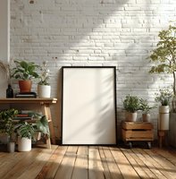 Blank frame mockup against white brick wall with houseplants, wooden floor, and natural light for home decor presentation.