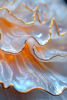 Macro photography of wavy golden lines against ethereal pearly surface creating abstract pattern with orange and blue iridescent reflections and smooth curves.