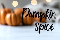 Pumpkin spice text overlay on blurred autumn pumpkins background with warm bokeh lights for seasonal marketing and fall advertising campaigns.