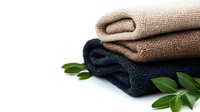 Folded soft cotton towels in beige and navy blue colors with fresh green leaves decoration on white background, minimalist spa and wellness concept.