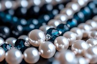 Elegant pearl necklace with blue crystal beads and rhinestone accents in macro photography, showcasing luxury jewelry details against dark background.