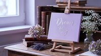 Inspirational dream big motivational quote on purple card displayed on wooden easel with dried flowers and vintage books creating cozy home decor atmosphere.