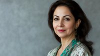 Professional Middle Eastern businesswoman in elegant attire smiling confidently against gray background for corporate presentations and marketing materials.