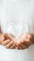 Hands holding glowing geometric heart shape with polygonal wireframe design representing love, care, protection and digital connection concepts.