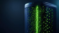 Glowing green particles floating in dark cylindrical container with illuminated vertical beam, creating futuristic scientific visualization effect.