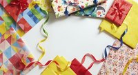 Colorful gift boxes with ribbons and bows arranged on white background, featuring red, yellow, and patterned wrapping paper for holiday celebrations and special occasions.