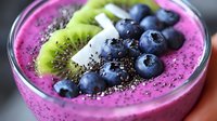 Vibrant purple smoothie bowl topped with fresh blueberries, sliced kiwi and chia seeds in glass bowl, healthy breakfast macro photography.