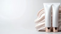 White cosmetic tubes with rose gold caps on draped beige silk fabric against light background, mockup for skincare and beauty product packaging design.