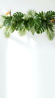 Tropical leaves border with monstera, palm fronds and bird of paradise flowers on white background for wedding invitations and summer designs.