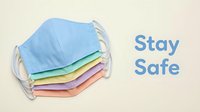 Stack of colorful pastel fabric face masks with Stay Safe text on beige background, promoting health and safety awareness.