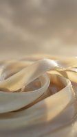 Fresh homemade pasta ribbons with water droplets on wooden surface ready for cooking in warm kitchen lighting for culinary content.