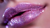 Sensual lips covered in sparkling pink and purple glitter makeup with glossy finish create glamorous beauty look for cosmetics advertising and fashion content.