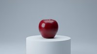 Red apple on white cylindrical pedestal against gray background for healthy eating and nutrition concepts.
