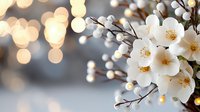 Delicate white spring blossoms against blurred golden bokeh background create dreamy romantic atmosphere, fresh floral composition for wedding and celebration designs.