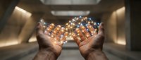 Hands holding glowing network of connected dots and lines representing digital connectivity, technology innovation, and data visualization in modern setting.