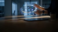 Businessman hands protecting glowing digital network sphere with connected nodes in modern office environment for cybersecurity and data protection concepts.