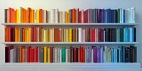Colorful books arranged by spectrum on white shelves, creating rainbow effect for modern home decor or library organization.