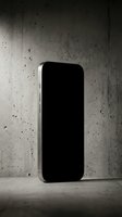 Smartphone with blank black screen leaning against textured concrete wall in minimalist industrial setting, suitable for app mockups and tech marketing materials.