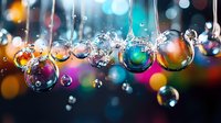 Transparent water drops with colorful bokeh reflections hanging in air against blurred festive background creating magical atmospheric effect.