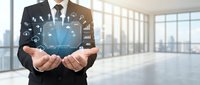 Professional businessman holding digital globe with network connections and data icons in modern office space for global business technology concepts.