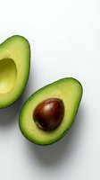 Fresh ripe avocado halves with pit on white background isolated for healthy cooking and nutrition design projects.