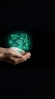 Hands holding glowing green holographic icons with brain, heart, leaf symbols representing mental health, wellness and sustainable living concepts.