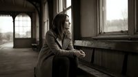 Young African American woman sitting pensively by window in abandoned building, contemplative mood, urban exploration, solitude and reflection concept.