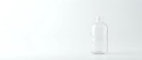 Empty clear glass bottle with cap on white background, suitable for product mockups, packaging design, and beverage branding projects.
