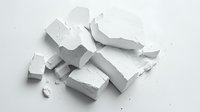 Broken white chalk pieces scattered on light background, creating dramatic shadows and depth. Clean minimalist composition on isolated surface.