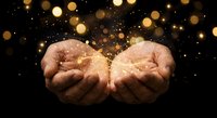Cupped hands releasing magical golden light particles and sparkles against dark background creating mystical atmosphere for spiritual and fantasy concepts.