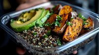 Healthy meal prep container with roasted tofu, quinoa, avocado and vegetables for lunch or diet planning.