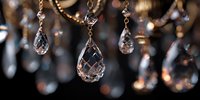 Elegant crystal chandelier with sparkling teardrop pendants and golden chains creating luxurious lighting ambiance for interior design and home decor.