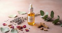 Botanical skincare serum bottle with natural ingredients lavender petals cinnamon sticks eucalyptus leaves on pink background for wellness beauty routine.