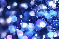 Magical blue bokeh lights creating dreamy abstract background with glowing circles and sparkles. Festive blurred pattern suitable for holiday designs and celebrations.