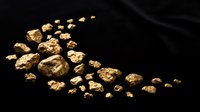 Golden nuggets and flakes scattered on dark surface representing precious metal mining wealth and natural treasure discovery for investment concepts.