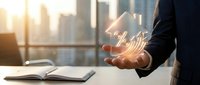 Businessman holding glowing house icon in modern office with city skyline at sunset representing real estate investment and property management.
