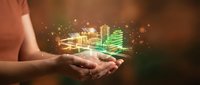 Hands holding glowing neon cityscape with digital buildings and light particles, representing smart city technology, urban development, and innovation for business and tech concepts.
