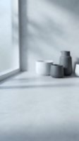 Blurred minimalist interior with ceramic vessels on windowsill creating soft natural lighting and shadows for modern home decor and lifestyle concepts.